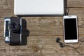 Camera phone and laptop are on a wooden table Royalty Free Stock Photo