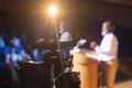 Camera recording businessman giving speech in auditorium Royalty Free Stock Photo