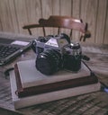 Camera Sitting on Three Journals on Top of a Wooden Textured Table