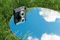 camera and sky reflection in round mirror on grass Royalty Free Stock Photo