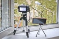 Camera and smartphone on tripods in front of an open window. Time lapse photography - smartphone vs camera Royalty Free Stock Photo