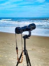 A camera on a tripod by the beach.