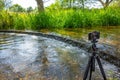 Camera on tripod capturing serene river scene. River Darent, Eynsford, UK