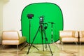 The camera on the tripod, led floodlight, headphones and a directional microphone on a green background. The chroma key Royalty Free Stock Photo