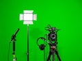 The camera on the tripod, led floodlight, headphones and a directional microphone on a green background. The chroma key Royalty Free Stock Photo