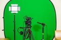 The camera on the tripod, led floodlight, headphones and a directional microphone on a green background. The chroma key Royalty Free Stock Photo