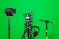 The camera on the tripod, led floodlight, headphones and a directional microphone on a green background. The chroma key Royalty Free Stock Photo