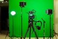 The camera on the tripod, led floodlight, headphones and a directional microphone on a green background. The chroma key Royalty Free Stock Photo