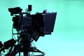 The camera on the tripod, led floodlight, prompter and a monitor on a green background.