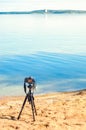 A camera on a tripod on the sandy beach