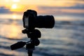 Camera on tripod by the sea in evening light. Camera at sunset. Royalty Free Stock Photo