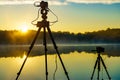 Camera on tripod take photo from sunrise over lake Royalty Free Stock Photo