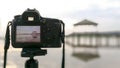 The camera is on a tripod, taking a photo of a pavilion in a pool or swamp or lake. Royalty Free Stock Photo