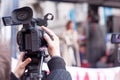 Camera operator recording female speaker at public protest