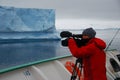Cameraman filming an iceberg in antarctica Royalty Free Stock Photo