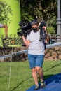 A cameraman and journalist records and reports on the development of a triathlon event.