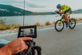 A cameraman with professional equipment and camera stabilization films a triathlete on the move riding a bicycle