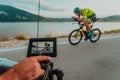 A cameraman with professional equipment and camera stabilization films a triathlete on the move riding a bicycle