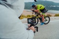 A cameraman with professional equipment and camera stabilization films a triathlete on the move riding a bicycle