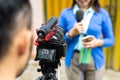 a cameraman recording the beautiful reporter using one set of camera