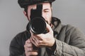 Cameraman with a retro camera in his hands, studio shot, close up. Old-fashioned clothing style, matte effect. Idea - movie of the Royalty Free Stock Photo
