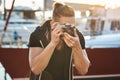 Cameraman trying hold still not to scare birds. Portrait of focused young male photographer looking through camera and