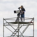 Cameraman working on steel scaffolding.