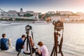 Cameras on tripods photograph a bridge and a river