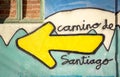 Camino de Santiago words and a yellow arrow painted on a wall on the way of Santiago Royalty Free Stock Photo