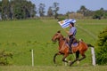 CAMINOS, CANELONES, URUGUAY, OCT 7, 2018: Gaucho riding a horse and waving the Uruguayan flag at a Festival in Uruguay Royalty Free Stock Photo