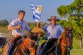 CAMINOS, CANELONES, URUGUAY, OCT 7, 2018: Gauchos riding horses and waving the Uruguayan flag at a Festival in Uruguay Royalty Free Stock Photo