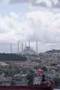 Camlica Mosque with its six minarets, seen from a boat on the Bosphorus, in the foreground a cargo ship with a Turkish boat and Royalty Free Stock Photo