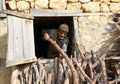 Unidentified Farmer taking out woods from window at Sebil Villag