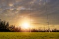 Camogie, hurling and rugby tall goalpost on a training pitch at sunset. Low angle of view. Sun flare and warm sunset sky. Irish