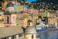 Colorful facades of historic buildings in the city of Camogli in Italy. Sea front houses, businesses and tourists on the stree