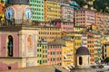 Colorful facades of historic buildings in the city of Camogli in Italy. Sea front houses, businesses and tourists on the stree