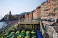 Beach with many green umbrellas and chaise loung in Camogli, Liguria, Italy