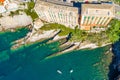 Camogli rocky coast aerial view. Boats and yachts moored near harbor with green water