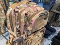 A camouflage backpack brown, green, beige against a military backdrop, under artificial lighting The backpack is the primary focus Royalty Free Stock Photo