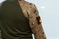 Camouflage with German national flag patch. Armed forces and security concept. Royalty Free Stock Photo