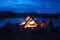 Camp fire burning in a fire pit next to the lake Royalty Free Stock Photo