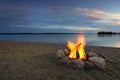 Camp fire on sandy beach, beside lake at sunset. Minnesota, USA