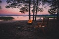 Camp fire on sandy beach, beside lake at sunset. Royalty Free Stock Photo
