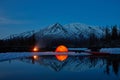 Camp near the mountain lake. Night landscape with a tent near the water.