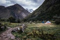 camp next to a trail with tents and pack mules surrounded by mountains and vegetation in the trekking of the quebrada santa cruz