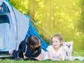 Camp in tent with children - girls sisters with little dog chihuahua sitting together near tent. Travelers sit in summer forest. Royalty Free Stock Photo
