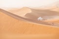 Camp with tent in the desert among sandy dunes. Sunny day in the Sahara during a sand storm in Morocco