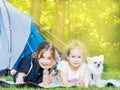 Camp in the tent - girls with little dog chihuahua sitting together near the tent. Camping with children Royalty Free Stock Photo