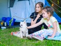 Camp in the tent - girls with little dog chihuahua sitting together near the tent Royalty Free Stock Photo