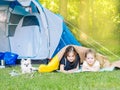 Camp in the tent - girls with little dog chihuahua sitting together near the tent. Camping with children Royalty Free Stock Photo